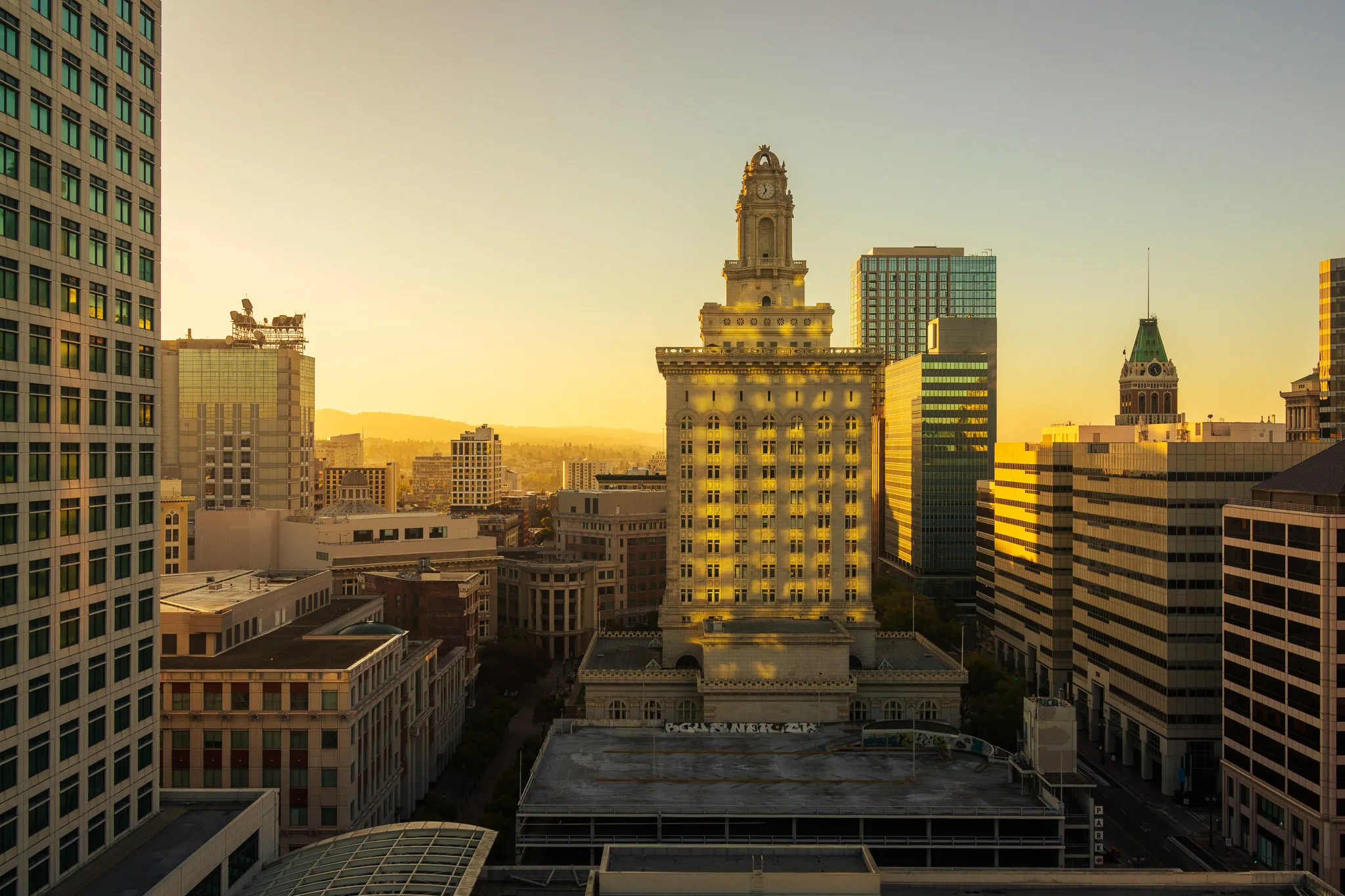 Oakland City Hall and downtown buildings at sunrise.